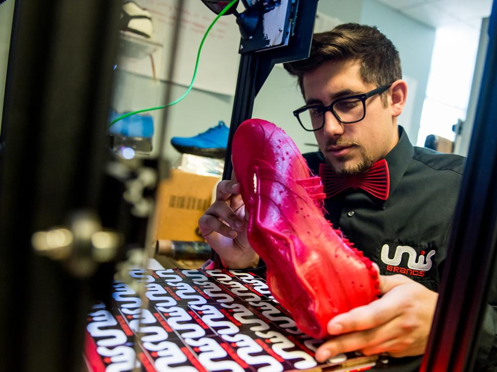 Nicholas Unis inspecting a prototype of his custom 3D printed footwear